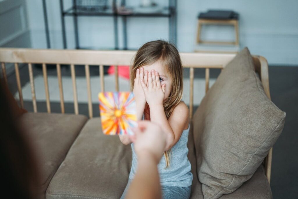 psicologia comportamental infantil - menina tampando o rosto com as mãos